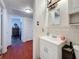 Simple bathroom showcasing vanity and mirror with tiled walls adjacent to a wood-look hallway at 3501 Beechwood N Ter, Pinellas Park, FL 33781