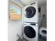 Bright laundry area featuring stacked washer and dryer, next to small window at 3501 Beechwood N Ter, Pinellas Park, FL 33781