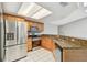 Well lit kitchen featuring stainless steel appliances, wood cabinets, granite countertops, and tile floors at 3767 Orchard Highlands Dr, Palm Harbor, FL 34684