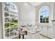 This bright bar area features granite countertops, white cabinets, and large arched windows with natural lighting at 3844 Wellington Pkwy, Palm Harbor, FL 34685