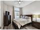 Cozy bedroom with a dark wood bed frame, dresser, nightstand, and natural light from a window at 3844 Wellington Pkwy, Palm Harbor, FL 34685