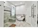 This main bathroom includes a standalone tub, walk-in shower, and travertine tile at 3844 Wellington Pkwy, Palm Harbor, FL 34685