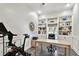 Bright office space featuring built-in bookshelves, a Peloton bike, and hardwood style floors at 3844 Wellington Pkwy, Palm Harbor, FL 34685