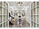 This home office features a large desk, custom shelving, French doors, and neutral paint at 3844 Wellington Pkwy, Palm Harbor, FL 34685