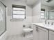 Clean bathroom features tiled walls, a window, and a vanity with plenty of storage space at 405 S Lake Dr, Clearwater, FL 33755