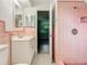 Charming pink tiled bathroom with vintage fixtures, offering a unique and nostalgic appeal at 405 S Lake Dr, Clearwater, FL 33755
