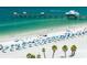 Bustling beach scene with umbrellas, palm trees and a pier visible in the distance at 405 S Lake Dr, Clearwater, FL 33755