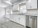 Well-lit kitchen boasts white cabinets, stainless steel appliances, and ample counter space at 405 S Lake Dr, Clearwater, FL 33755