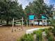 Community playground surrounded by a wood chip surface and mature trees at 405 S Lake Dr, Clearwater, FL 33755