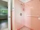 Close-up of a pink tiled shower with safety bar, offering a secure and stylish bathing experience at 405 S Lake Dr, Clearwater, FL 33755
