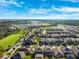 An expansive aerial perspective reveals homes nestled by green spaces, lakes, and commercial areas, under a sky filled with bright, fluffy clouds at 4195 Welling Ter, Land O Lakes, FL 34638