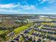 An aerial view captures the community with its homes, lakes, commercial zones, and greenery under a sunny sky at 4195 Welling Ter, Land O Lakes, FL 34638