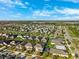 A wide aerial shot showcases the community, its homes, green spaces, and the overall neighborhood layout on a clear, sunny day at 4195 Welling Ter, Land O Lakes, FL 34638