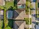 Aerial view of property showing the roof, screened-in pool and landscaping at 4195 Welling Ter, Land O Lakes, FL 34638