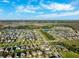 A bird's eye view highlights the community's design with homes, ponds, green spaces, and playgrounds under a bright blue sky at 4195 Welling Ter, Land O Lakes, FL 34638