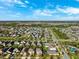 An aerial view captures the community's layout with homes, ponds, and greenbelts against a backdrop of clear blue skies at 4195 Welling Ter, Land O Lakes, FL 34638