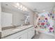 Bathroom featuring granite countertops with dual sinks and a shower with floral curtain at 4195 Welling Ter, Land O Lakes, FL 34638