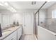 Bright bathroom featuring double sinks, a walk-in shower, and neutral wall color at 4195 Welling Ter, Land O Lakes, FL 34638