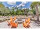 Outdoor fire pit with orange Adirondack chairs for a cozy gathering spot at 4195 Welling Ter, Land O Lakes, FL 34638