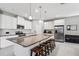 Bright kitchen features white cabinets, stainless appliances, and large island with seating at 4195 Welling Ter, Land O Lakes, FL 34638