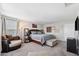 Carpeted primary bedroom with natural light, an accent chair, and an ensuite bathroom at 4195 Welling Ter, Land O Lakes, FL 34638