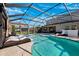 Open screened-in pool with hot tub and lounge chairs, with the covered lanai of the home in the background at 4195 Welling Ter, Land O Lakes, FL 34638