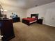 Spacious bedroom featuring carpeted floors, dark wood furniture, and a large window for natural light at 4210 Pacente Loop, Zephyrhills, FL 33543