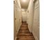 Hallway featuring wood-look flooring and multiple closet doors at 4210 Pacente Loop, Zephyrhills, FL 33543