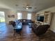 Comfortable living room features a large sectional sofa, ceiling fan, and entertainment center at 4210 Pacente Loop, Zephyrhills, FL 33543