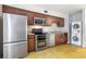 Traditional-style kitchen features stainless steel appliances, wood cabinets, and a stacked washer/dryer at 4215 La Sorrento Ct, Tampa, FL 33611