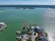 Aerial view of the waterfront property, with the house pointed out by a pink arrow, and the harbor behind at 447 22Nd St, Belleair Beach, FL 33786