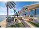 A beautiful backyard patio with an in-ground pool overlooking the water on a sunny day at 447 22Nd St, Belleair Beach, FL 33786