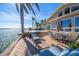 Relaxing backyard patio with in-ground pool and waterfront views on a sunny day at 447 22Nd St, Belleair Beach, FL 33786