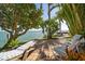 Relaxing backyard featuring an attractive patio, lounge chairs, and a picturesque view of the water at 447 22Nd St, Belleair Beach, FL 33786