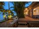 An outdoor lounge area with lush landscaping and waterfront views at twilight at 447 22Nd St, Belleair Beach, FL 33786
