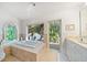 Bathroom with tub, garden view, and single vanity with cabinets at 447 22Nd St, Belleair Beach, FL 33786