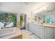 Bathroom with tub, garden view, and double vanity with cabinets at 447 22Nd St, Belleair Beach, FL 33786