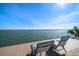 Relaxing lounge chairs on a wooden deck with a beautiful ocean view under a clear blue sky at 447 22Nd St, Belleair Beach, FL 33786