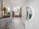 Bright foyer with tile flooring and a decorative front door and a glimpse into the living room at 447 22Nd St, Belleair Beach, FL 33786