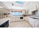 Well-lit kitchen featuring a skylight, tile backsplash, and ample counter space at 447 22Nd St, Belleair Beach, FL 33786