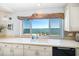 Bright kitchen features a sink with a waterfront view and unique driftwood accent above the window at 447 22Nd St, Belleair Beach, FL 33786