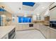 Bright kitchen with skylight, waterfront view, and white cabinets with stainless appliances at 447 22Nd St, Belleair Beach, FL 33786