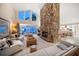 Open living room with a stone fireplace, vaulted ceilings, and views of the water and lush greenery at 447 22Nd St, Belleair Beach, FL 33786