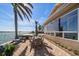 Beautiful outdoor patio with dining set, lounge chairs, lush landscaping and stunning waterfront view at 447 22Nd St, Belleair Beach, FL 33786