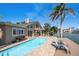 Inviting pool overlooking the water, surrounded by palm trees and blue skies at 447 22Nd St, Belleair Beach, FL 33786