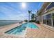 Inviting pool overlooking the water, surrounded by palm trees and blue skies at 447 22Nd St, Belleair Beach, FL 33786