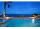 Inviting waterfront pool with two lounge chairs on the brick-paved pool deck under the light of early evening at 447 22Nd St, Belleair Beach, FL 33786