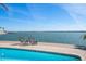 Waterfront property with pool and deck overlooking peaceful water views on a bright, sunny day at 447 22Nd St, Belleair Beach, FL 33786