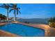 Inviting waterfront pool area with lounge chairs and stunning bay views at dusk at 447 22Nd St, Belleair Beach, FL 33786