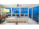 Bright sunroom with tile floors, ceiling fan, and stunning water views through large windows and sliding glass doors at 447 22Nd St, Belleair Beach, FL 33786